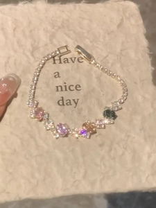 Detail of colorful oval gemstones and cubic zirconia pavé on a gold-plated link bracelet