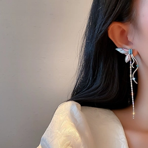 Detail of silver needle butterfly tassel earring with crystal chains on model side profile