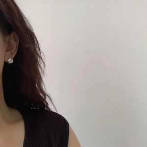 Minimalist silver spherical hoop earrings for women shown worn on a model's ear
