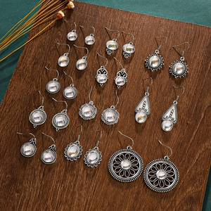 Vintage silver moonstone earring set with water drop and floral designs on wood