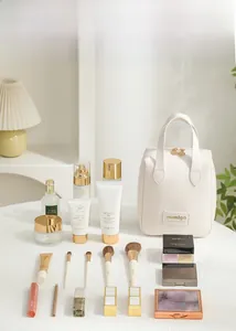 Detail of a creamy white PU leather shell makeup bag with gold zippers on a vanity