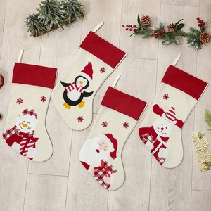 Set of 4 Christmas stockings with Santa, snowman, penguin and reindeer on wood floor