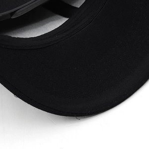 Détail macro des coutures multi-rangées sur la visière d'une casquette noire