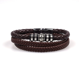 Detail of multilayer brown braided leather bracelet with silver metal beads and magnetic clasp