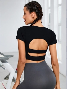 Detail of black open back yoga crop top with ribbed fabric and cutout design