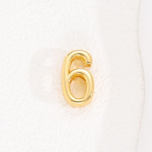 Close-up of a metallic gold number 6 charm for a 10mm stainless steel mesh bracelet