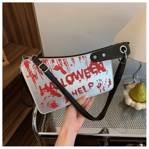 Detail of silver kitchen knife handbag with red blood splatters and black leather strap