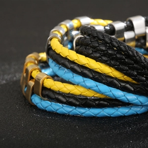 Macro detail of multi-layer braided leather bracelets with silver and gold metal accents