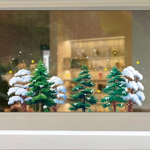 Detail of white snowy pine trees and yellow star static window stickers on glass