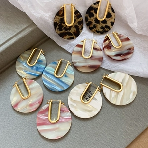 Détail de boucles d'oreilles en U plaquées or 18k avec disques d'acétate marbré assortis