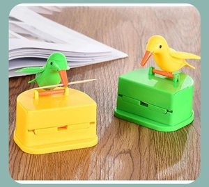 Bird-shaped automatic toothpick dispenser on wooden desk for home storage and decor