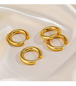 Detailed view of polished 18K gold-plated hoop earrings on elegant silk fabric