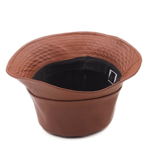 Close-up of brown leather bucket hat showing detailed stitching and internal fabric lining