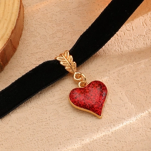 Dettaglio pendente cuore rosso glitter su choker in velluto nero con chiusura a foglia