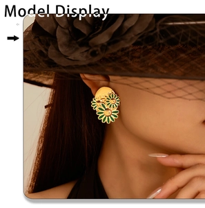 Model wearing 18k gold daisy earrings with green petals and retro floral texture