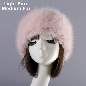 Detail view of a plush light pink faux fur hat displayed on a model head stand