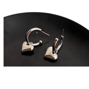 Silver metal heart hoop earrings featuring a minimalist polished heart-shaped pendant design