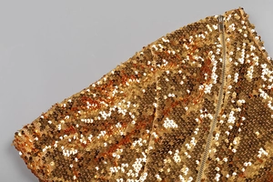 Détail de la fermeture éclair et des paillettes dorées sur une robe bustier ajustée