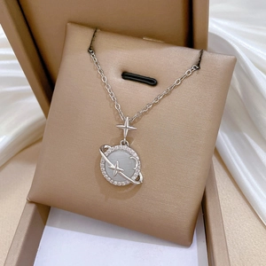 Detailed close-up of a silver planet necklace with cat eye stone and cubic zirconia inlay