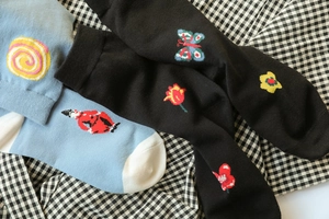 Detail of cotton crew socks featuring colorful jacquard ladybug and floral patterns