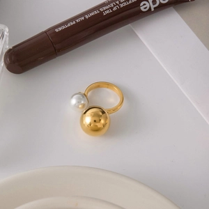 Detail of 18K gold stainless steel ring with asymmetric gold ball and white pearl