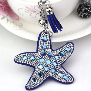 Detail of blue starfish keychain with leather base, rhinestones, and elegant silk tassel