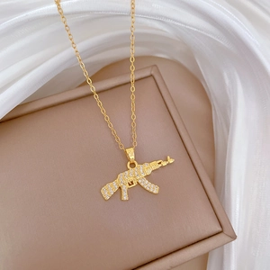 Detail of gold AK-47 assault rifle pendant with glittering rhinestones on silk