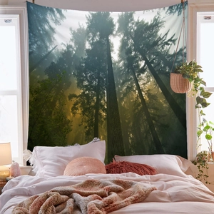 Dettaglio di un arazzo forestale appeso sul letto con luce tra alberi nebbiosi