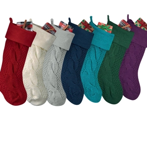 Set of seven knit Christmas stockings in various colors with classic cable patterns