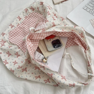 Détail du sac cabas en toile avec motifs nœuds roses, fleurs et poche intérieure en dentelle