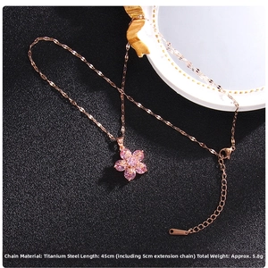 Detailed view of rose gold clover pendant with pink zircon in a high-contrast setting