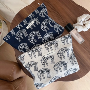 Detail of canvas pouches with sheep pattern prints and simple wish woven label