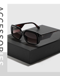 Detail of vintage square sunglasses featuring tortoiseshell temples and metal rivets