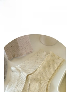 Close-up of Japanese style knit socks featuring flecked yarn and delicate lace cuffs