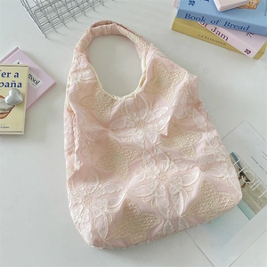 Vue détaillée du sac cabas en dentelle rose avec broderies papillon blanches