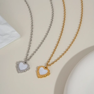Détail de pendentifs coeur en nacre avec bordures en dentelle dorée et argentée