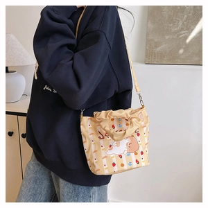 Detail of cute canvas bucket bag with yellow stripes and cartoon animal print
