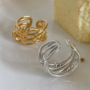 Detailed view of silver and gold multilayer hollow rings on a ceramic plate
