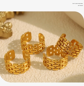 Detail view of four gold-plated titanium rings with unique watchband chain texture design