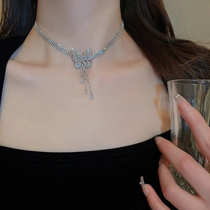 Detail of silver butterfly pendant necklace with zircon fringe worn by a model