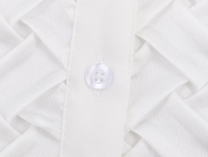 Détails de chemise en satin blanc montrant la patte de boutonnage et les plis élégants