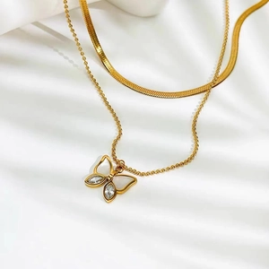 Golden double-layer butterfly pendant necklace with snake and bead chains on white silk