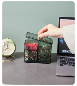 Detailed close-up of dark green acrylic organizer with gold handle lid on desk