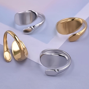 Detailed view of four minimalist wavy open rings in gold and silver finishes