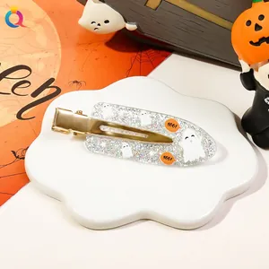 Detail of Halloween hair clip with silver glitter and white ghost on a cloud tray