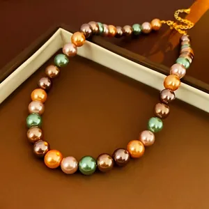 Bracelet luxueux en perles colorées avec fermoir doré sur écrin en cuir marron élégant