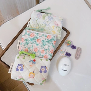 Detailed close-up of quilted cotton floral coin purses with textured zipper pulls