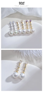 Close-up of S925 silver pearl drop earrings with purple zircon and golden metal finish