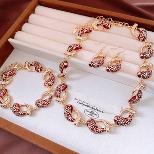 Detailed close-up of vintage gold necklace set with red enamel and zircon in a gift box