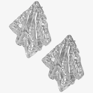 Macro view of irregular pleated silver earrings with liquid metal textured surface